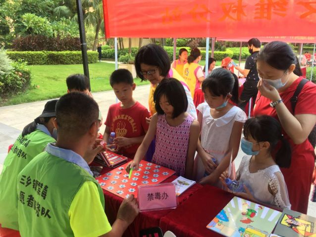 親子家庭在禁毒志愿者的引導下進行禁毒小游戲.jpg